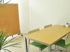 明るいダイニングテーブルと椅子が配置された共用スペース